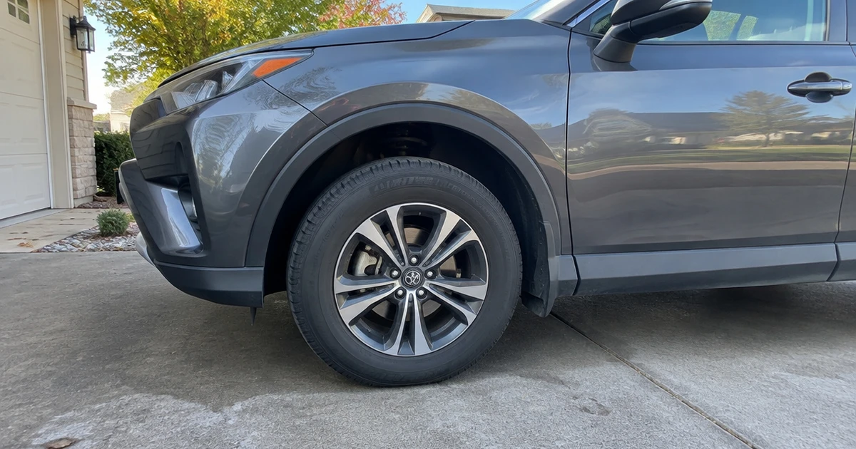 An SUV parked on a gravel drive with All Season Tires for SUVs fitted
