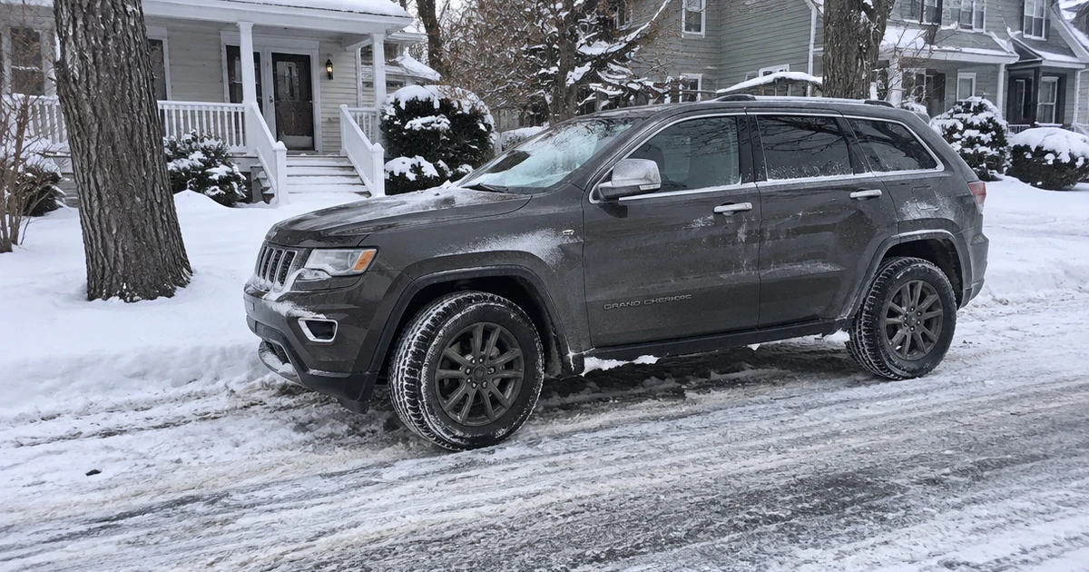 Snow Tires for SUVs grip a parked crossover on a snowy neighborhood street