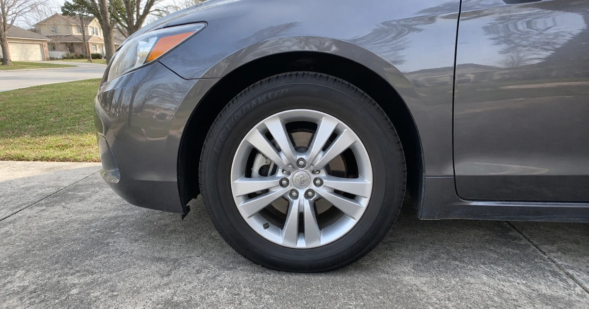Tires for a Quiet Ride mounted on a family car in a sunlit driveway