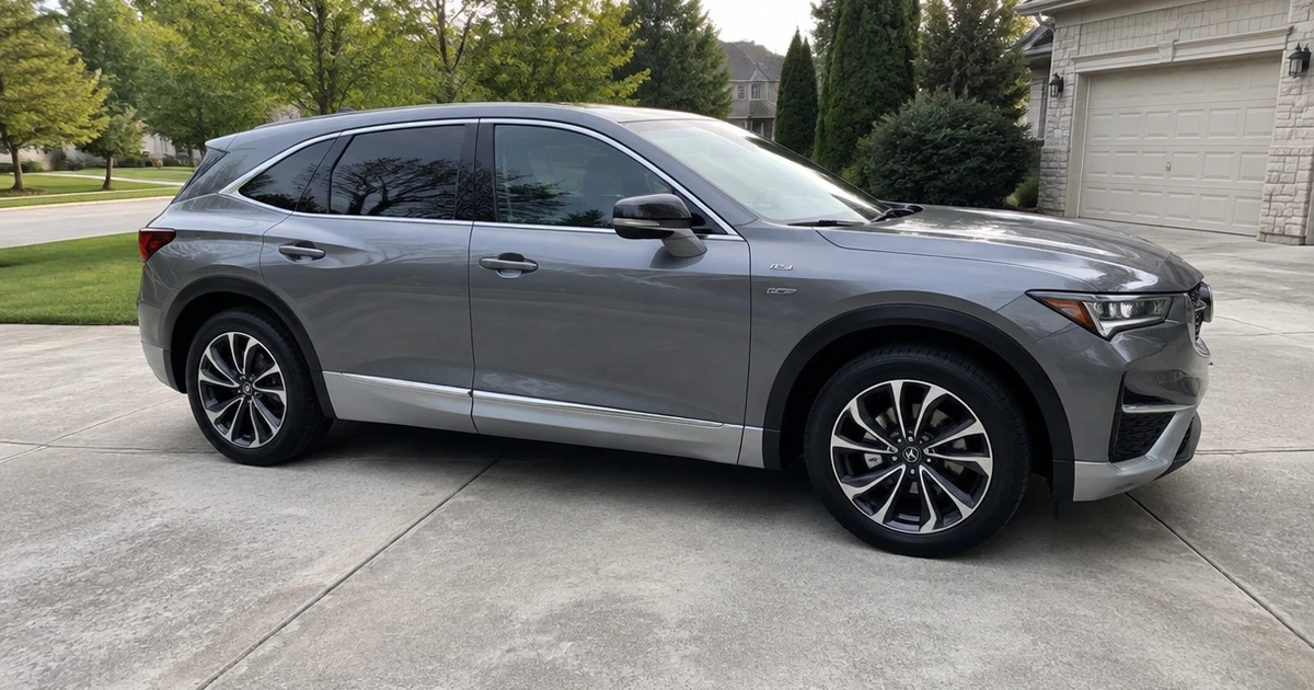A tire for Acura ZDX sits on an SUV in a sunlit residential driveway