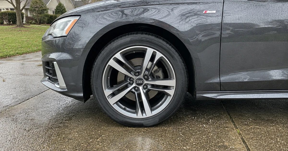 An Audi A4 fitted with tires for Audi A4 sits on a neighborhood street in daylight