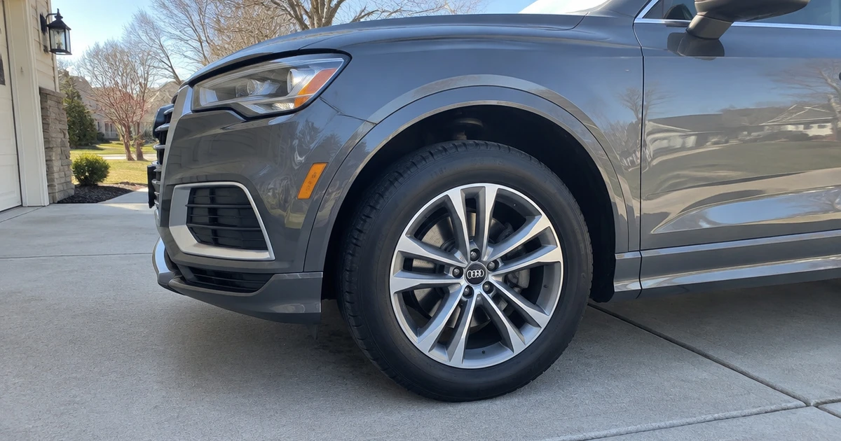 A generic tire for Audi Q3 mounted on a parked crossover in a driveway