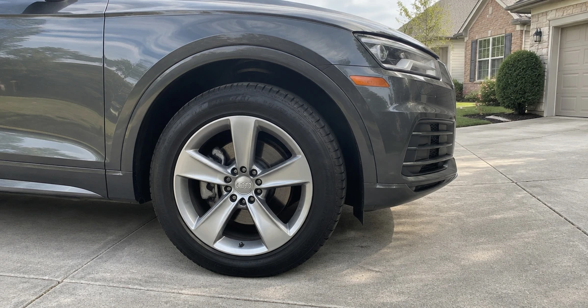 Tires for Audi Q5 are visible on a parked SUV in a sunny driveway