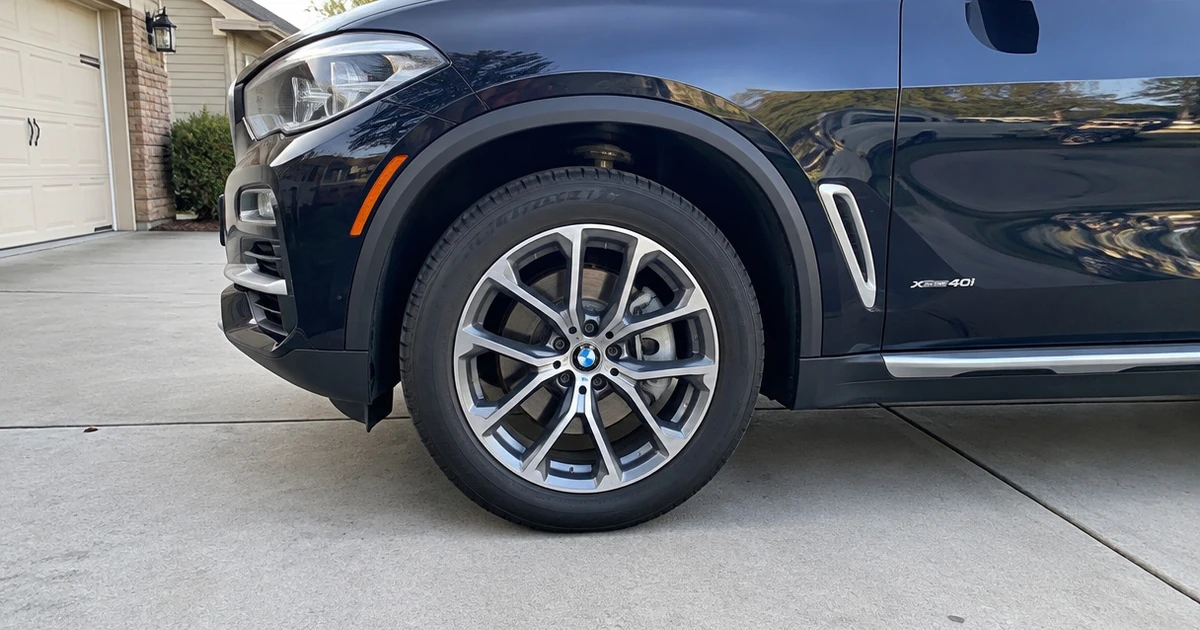 A BMW X5 sits in a driveway with tires for BMW X5 fitted