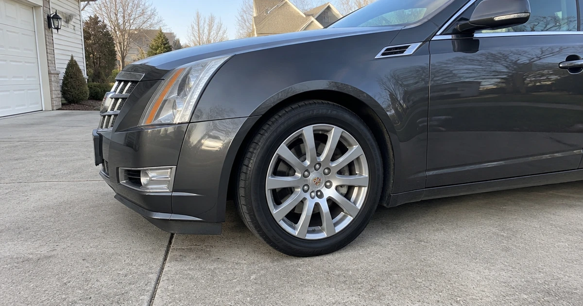 A Cadillac CTS with tires for Cadillac CTS parked on a residential driveway