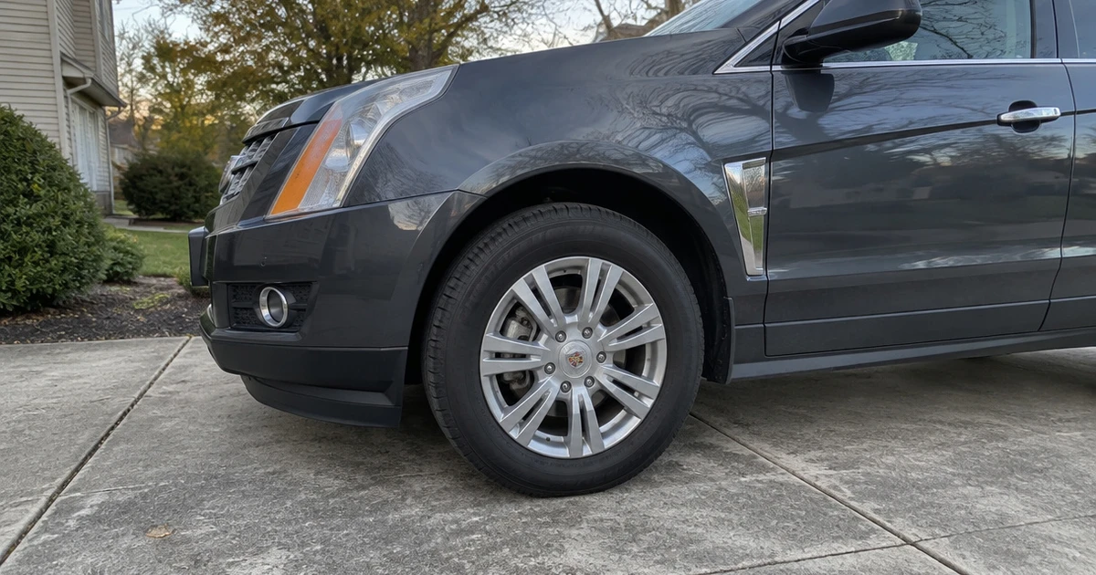A Cadillac SRX sits in a driveway with tires for Cadillac SRX clearly visible