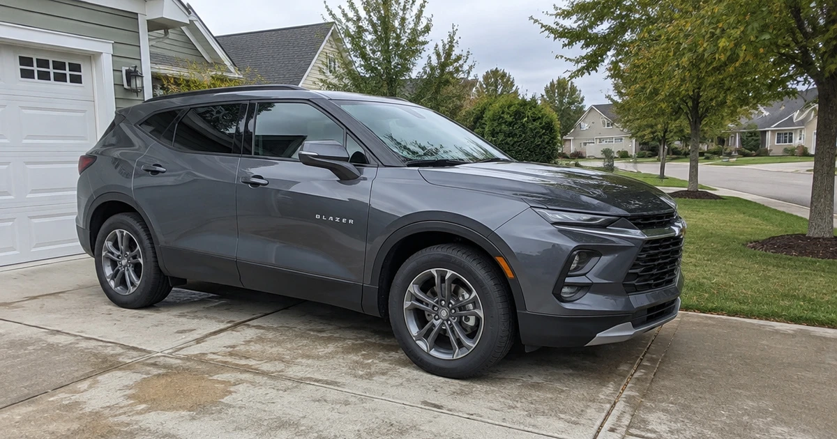 Tires for Chevy Blazer sit mounted on a dark SUV parked in a driveway