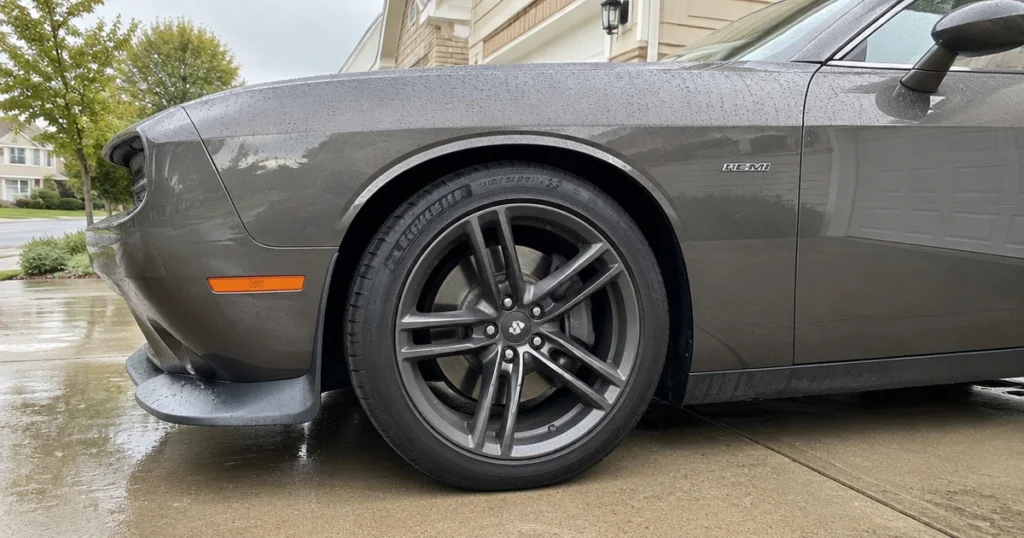 A Dodge Challenger rides on tires for Dodge Challenger beside a residential curb