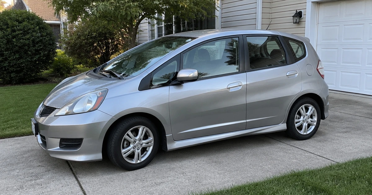 A Honda Fit on a driveway shows its tires for Honda Fit in clear view