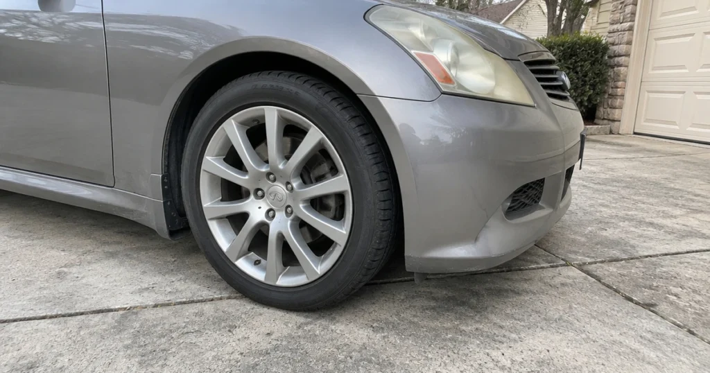 A black tire for Infiniti G35 sits fitted to the car in daylight