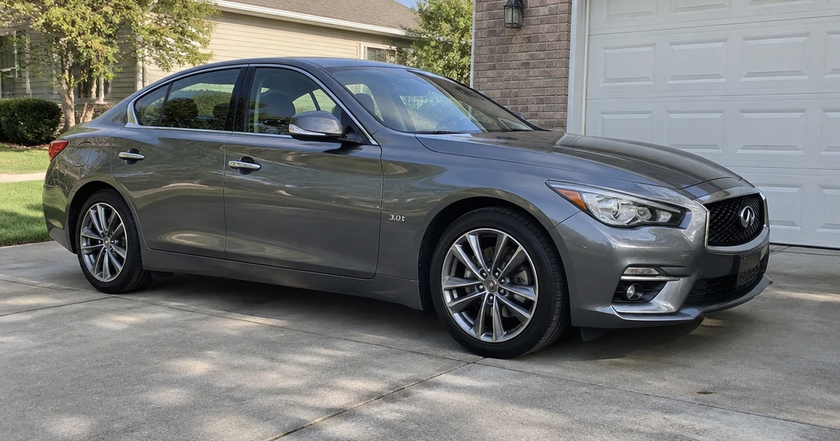 A sedan parked on a driveway with tires for Infiniti Q50 fitted to its wheels