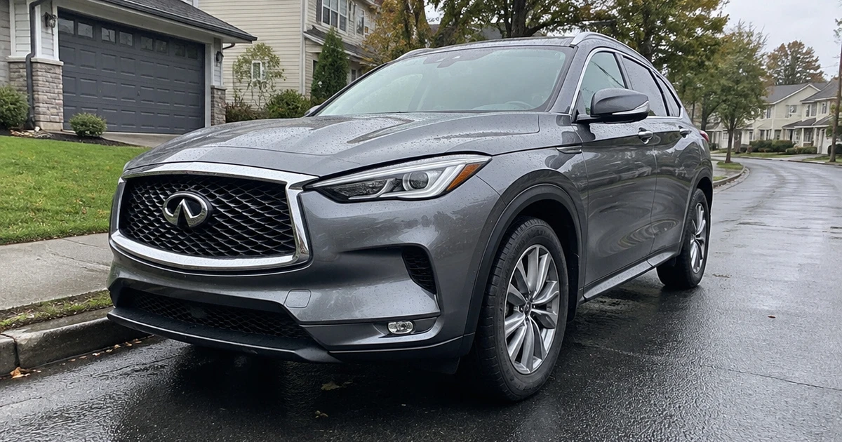 A dark SUV fitted with tires for Infiniti QX50 sits on a suburban driveway
