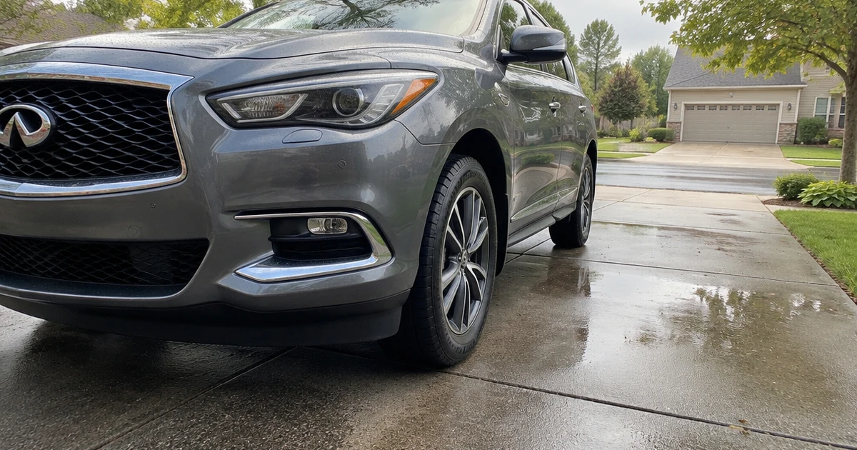A crossover parked on a driveway with tires for Infiniti QX60 clearly visible