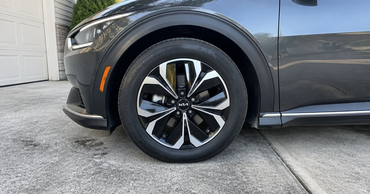 A Kia EV6 on a residential street with tires for Kia EV6 clearly visible