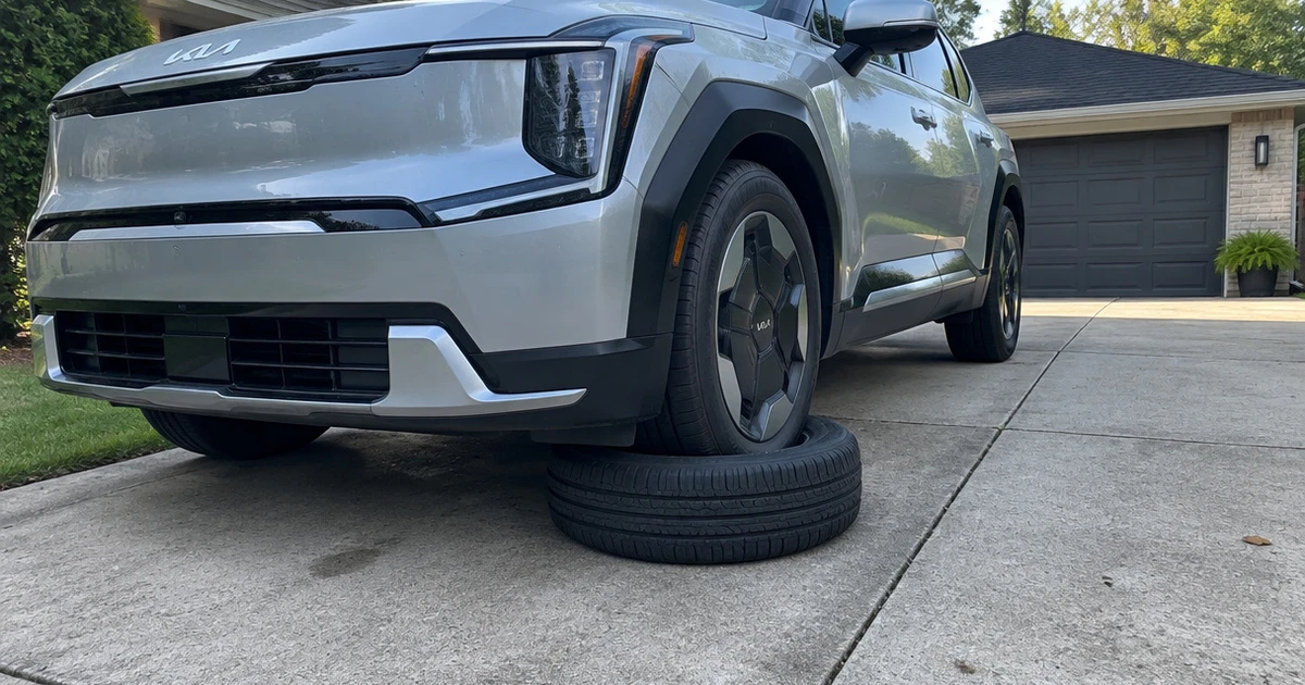 A Kia EV9 parked outdoors with a tire for Kia EV9 on its front wheel