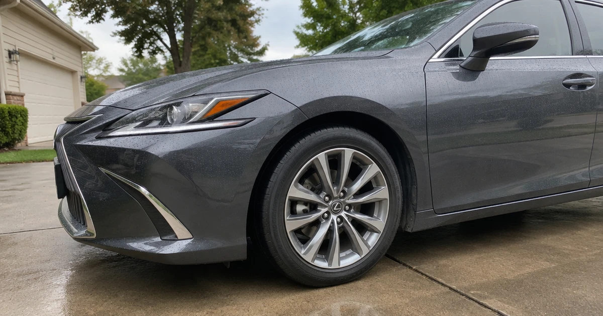 A Lexus ES sits in a driveway with its tire for Lexus ES clearly visible