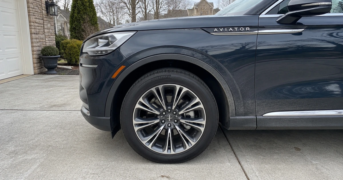A Lincoln Aviator sits on a driveway with tires for Lincoln Aviator fitted