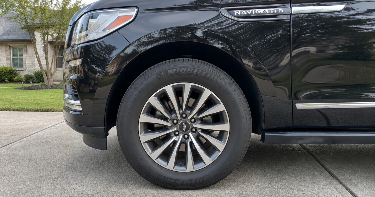 A Lincoln Navigator on a driveway with tires for Lincoln Navigator in clear view