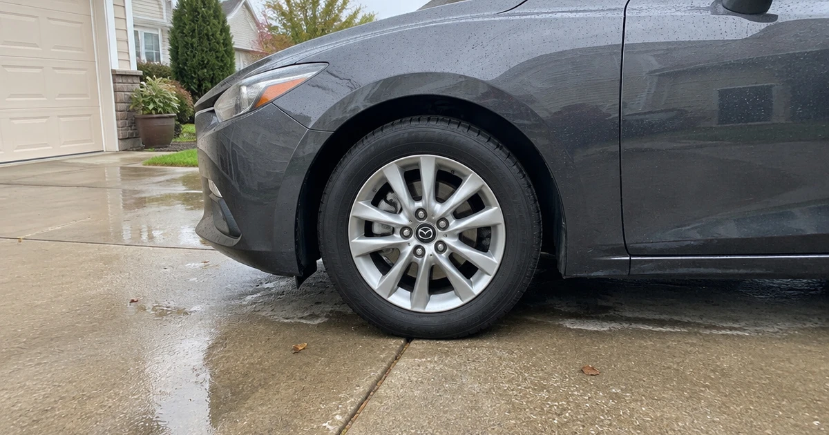 One tire for Mazda 3 stands out on a car parked in a sunlit driveway