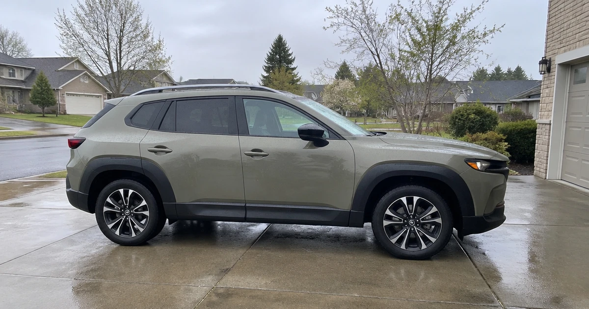 A Mazda CX-50 parked on a driveway with tires for Mazda CX-50 clearly visible