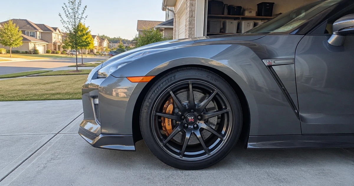 A close view shows tires for Nissan GT-R fitted to a parked coupe