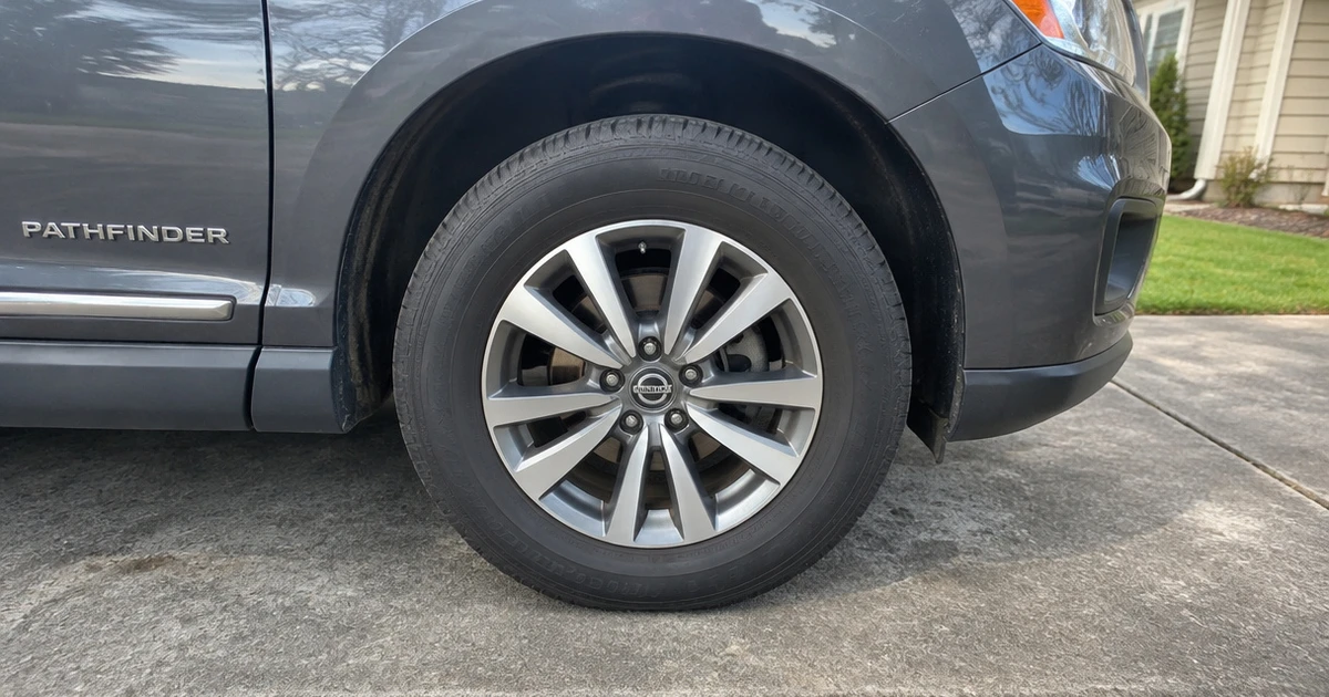 A Nissan Pathfinder parked outdoors with tires for Nissan Pathfinder fitted and visible