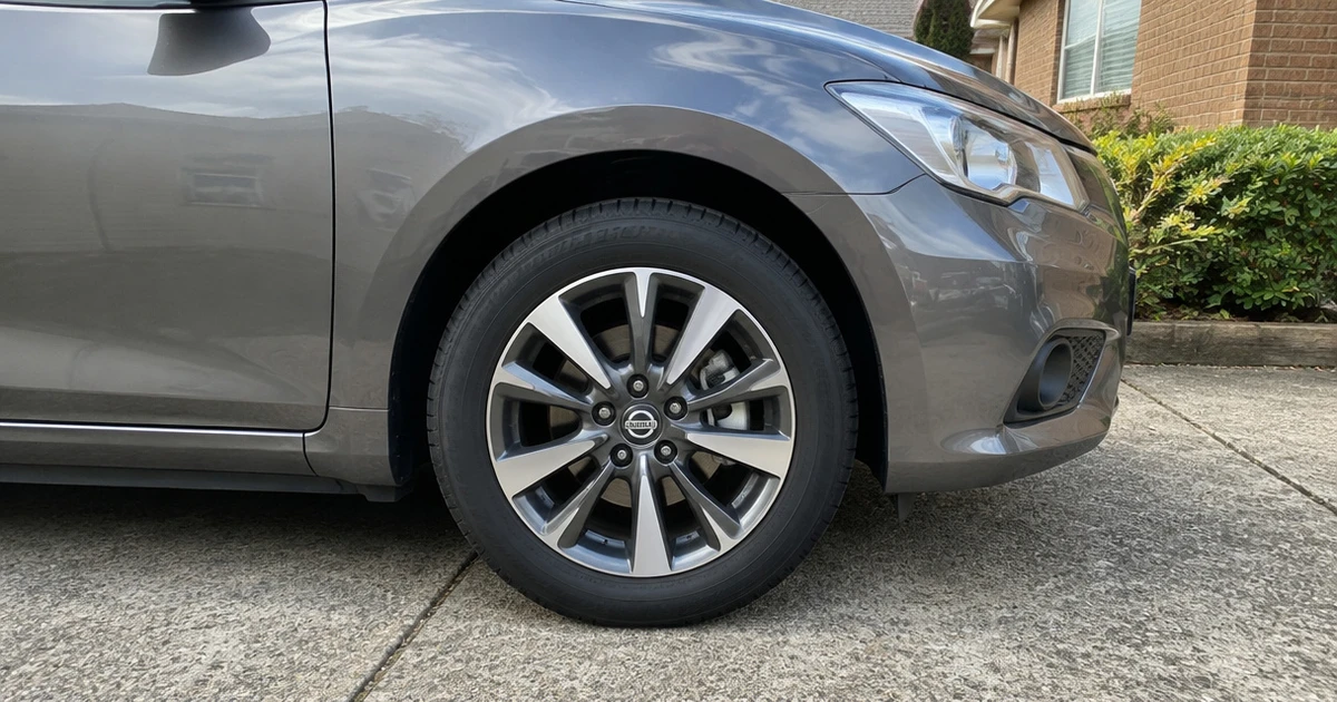 A Nissan Pulsar parked on a driveway with tires for Nissan Pulsar clearly visible