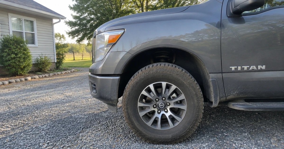 A Nissan Titan on gravel shows a tire for Nissan Titan in clear view