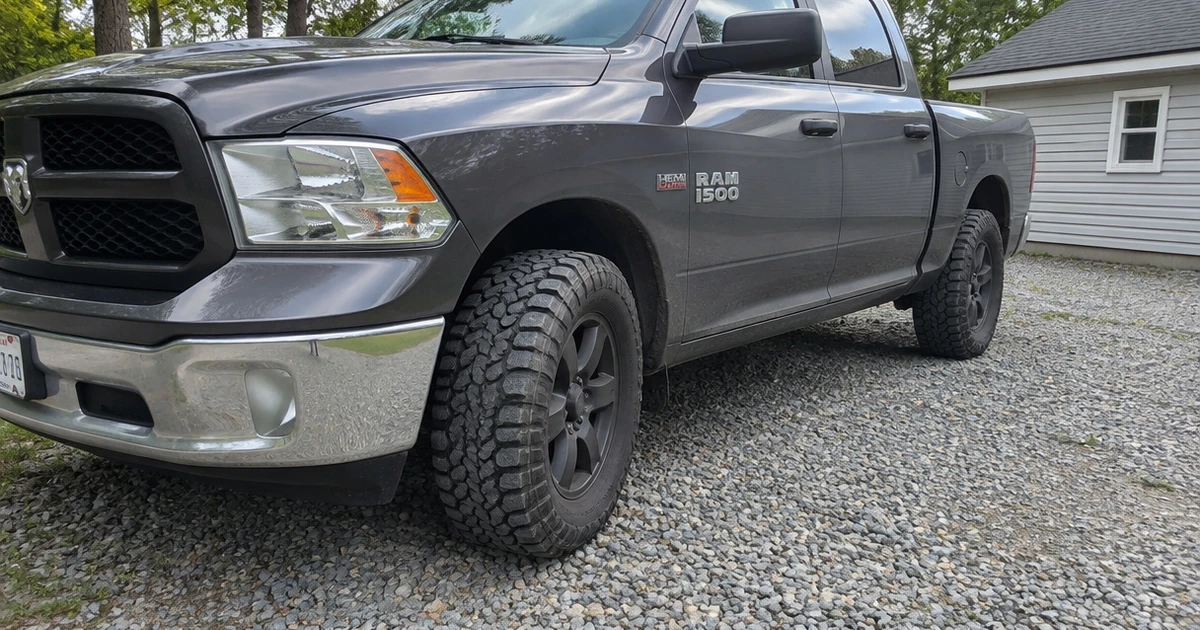 A Ram 1500 parked on a gravel drive with tires for Ram 1500 fitted