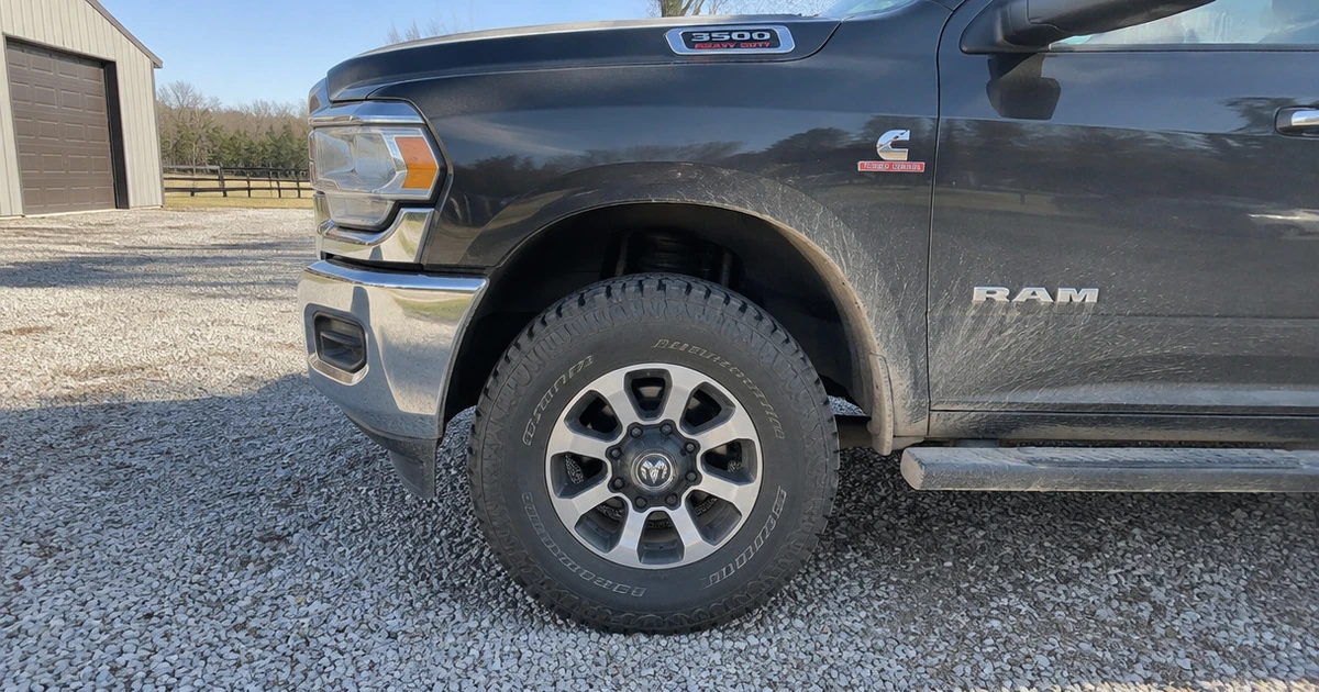 A Ram 3500 on a gravel drive shows tires for Ram 3500 in natural light