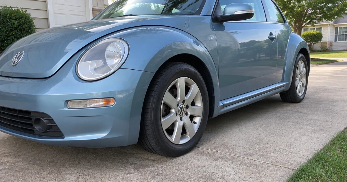 A tire for Volkswagen Beetle fitted on a parked Beetle in a driveway