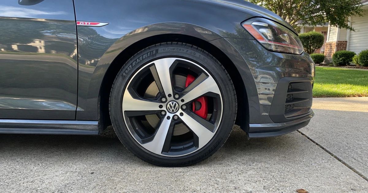 A Volkswagen GTI parked on a driveway shows its tires for Volkswagen GTI in clear view