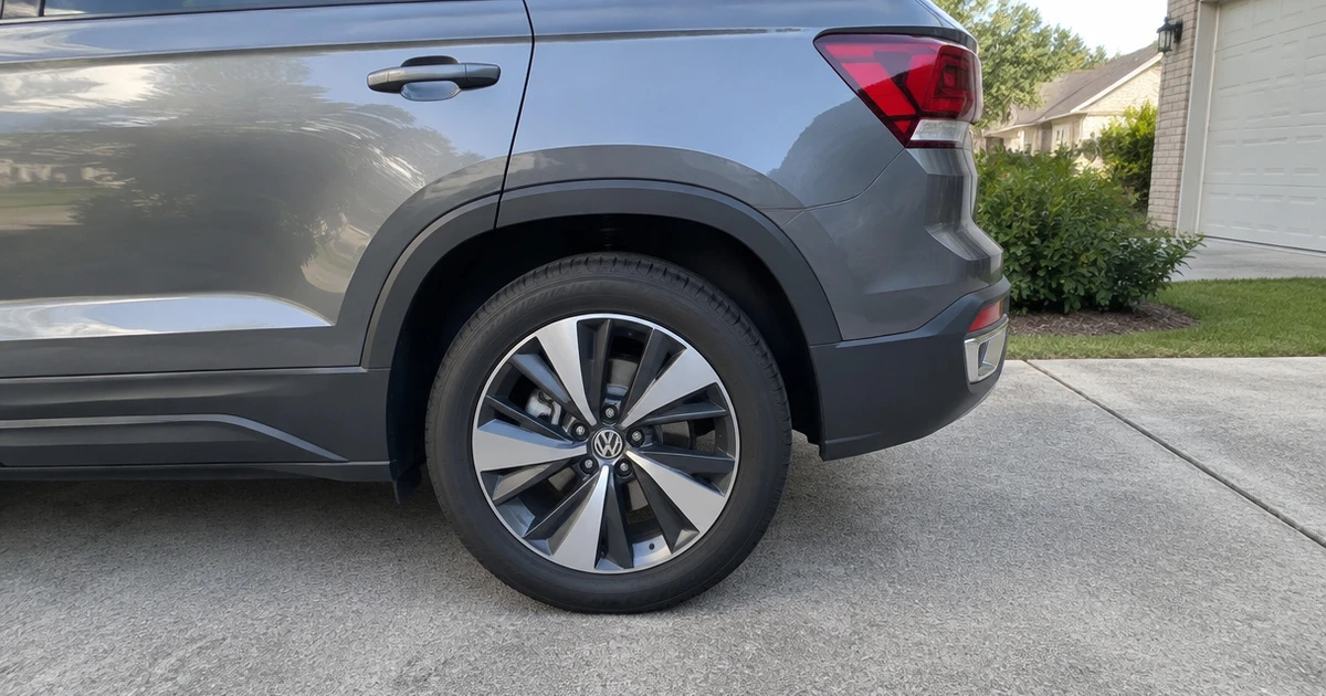 A Volkswagen Taos parked on a driveway with tires for Volkswagen Taos in view