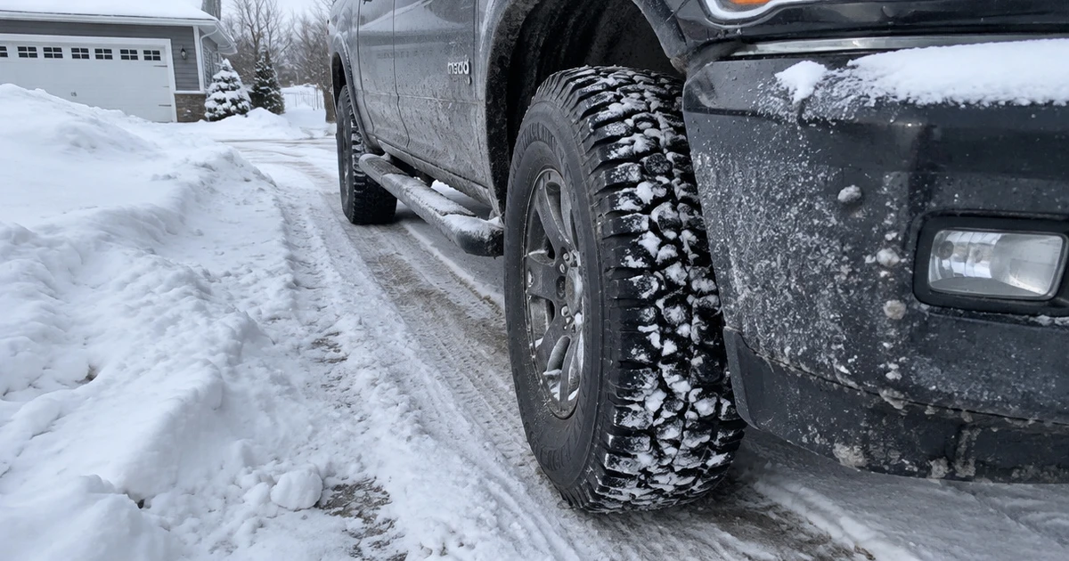 Winter Tires for Trucks mounted on a pickup parked along a snowy rural road